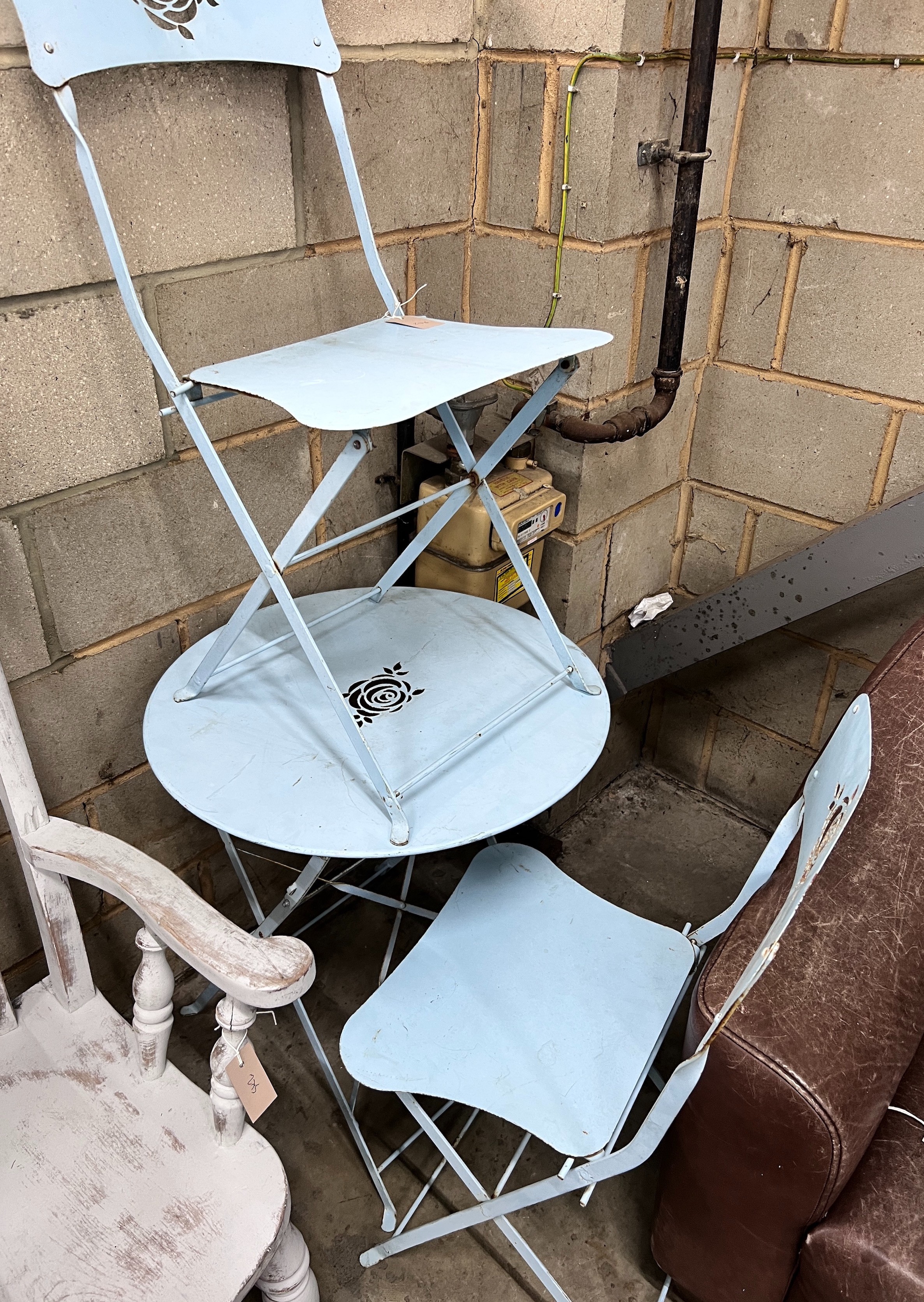 A blue painted wrought iron folding cafe table and pair of matching chairs, diameter 60cm, height 69cm *Please note the sale commences at 9am.